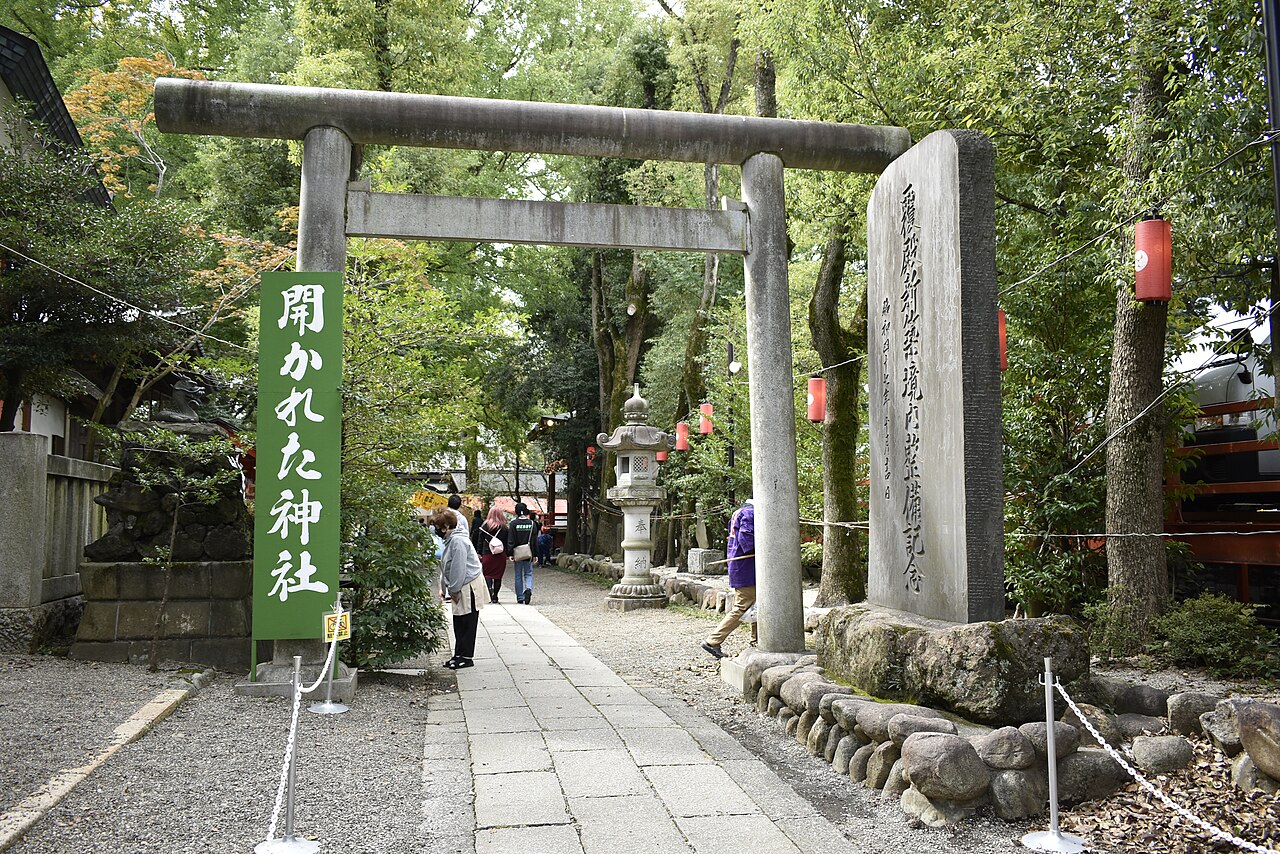 田無神社の石の鳥居と、緑の木々に囲まれた参道